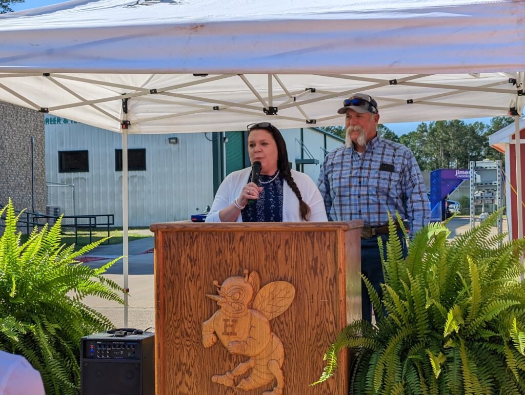 Tara and Roger Burnett speak at the Homes for Huntsville Heroes dedication ceremony at Huntsville High School on April 28, 2023.